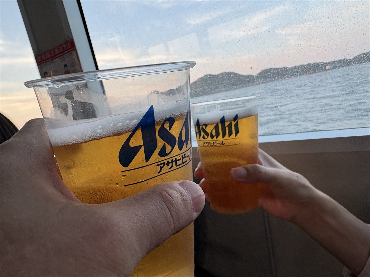 海を背にアサヒビールのカップで乾杯